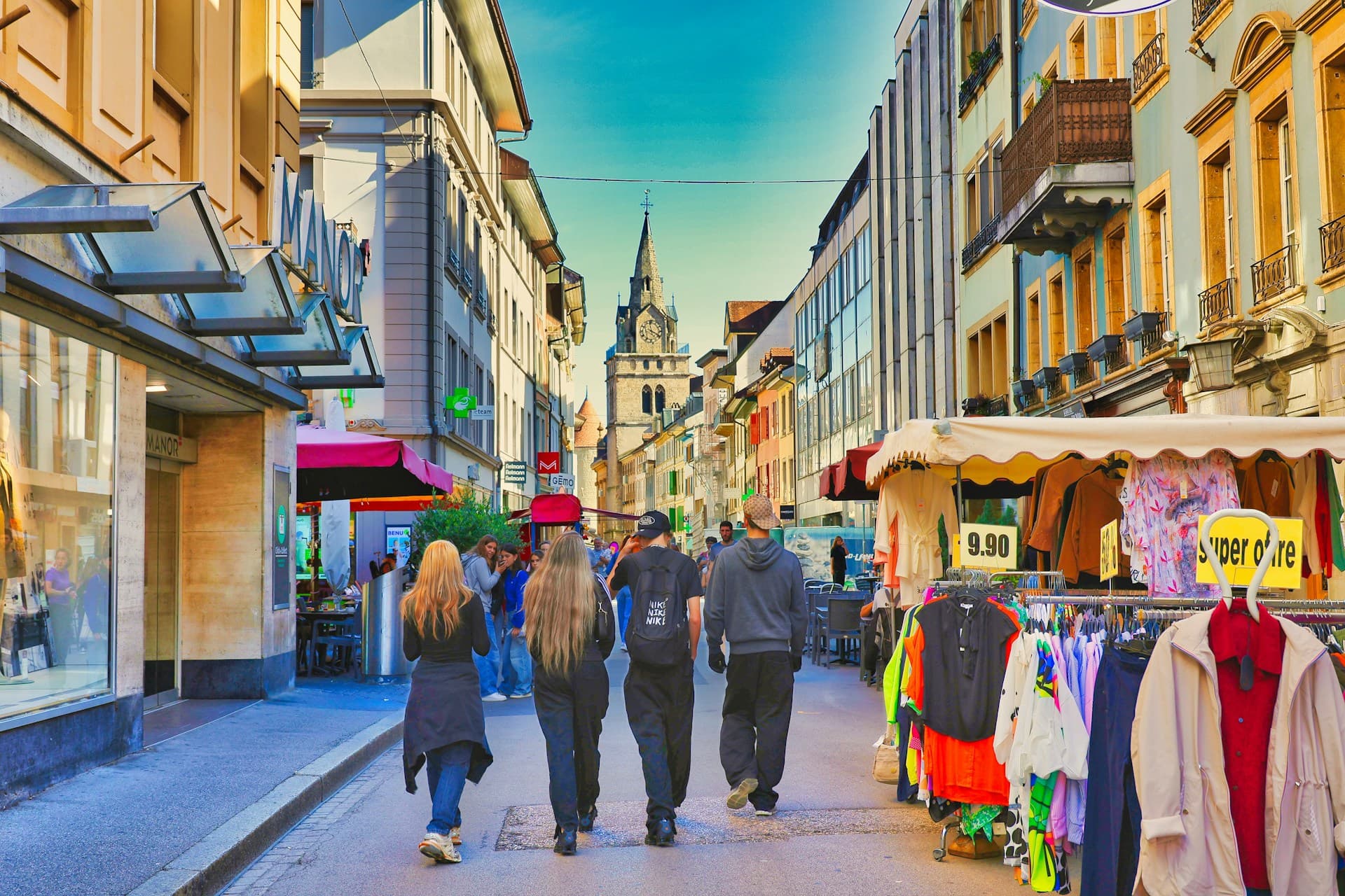 People walking along a sunny shopping street